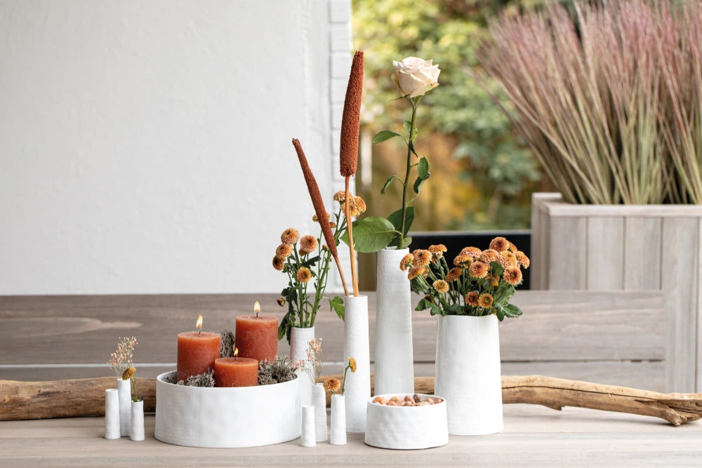 Weiße Vasen von Räder mit Blumen und Kerzen in unterschiedlichen Größen 