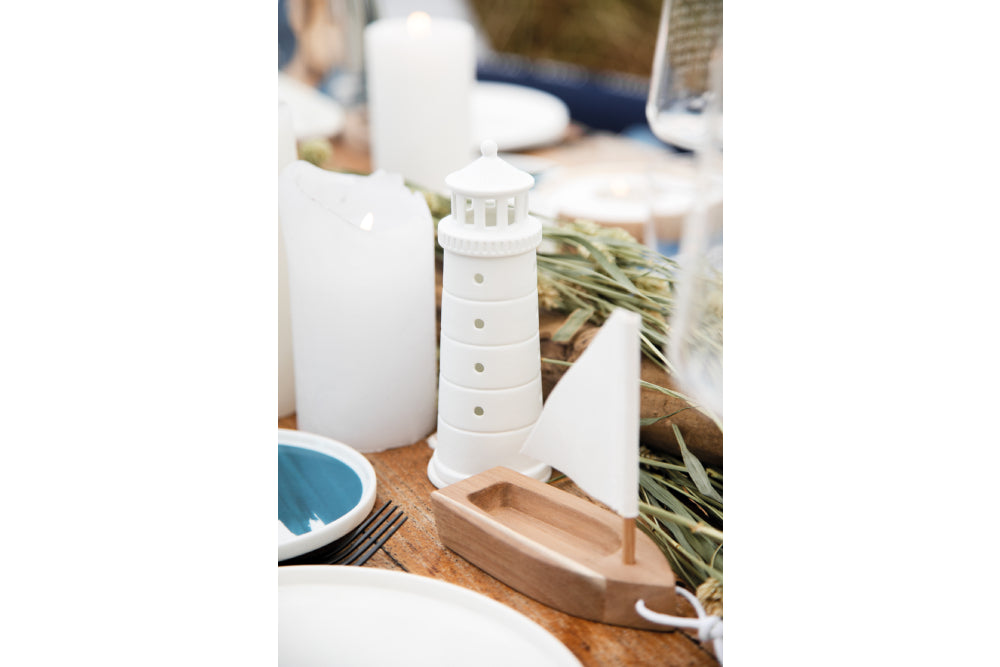 Räder Lichthaus Leuchtturm "Mittel" aus der Serie "Meer als Worte" auf einem gedeckten Tisch